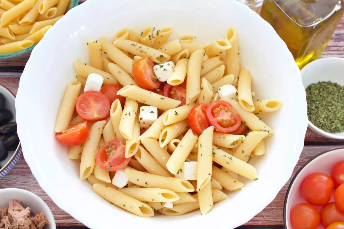 El queso feta y el orégano en el bol de la ensalada de macarrones fría