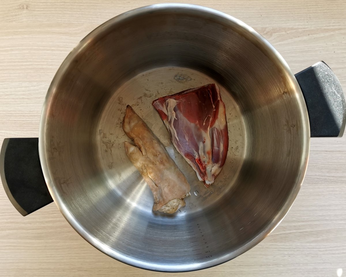 Empezar a cocer las carnes para el cocido maragato. empezando por la manita y el morcillo