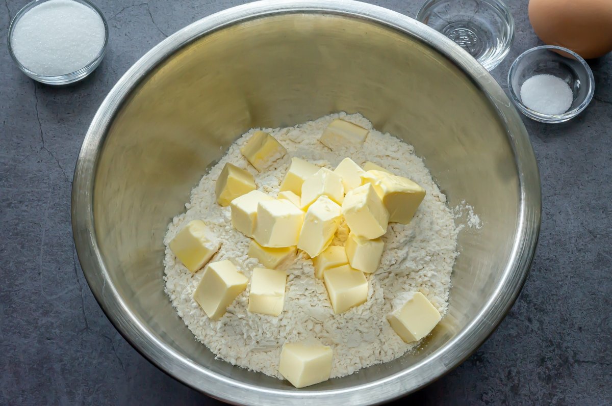 en un bol mezclar la harina, el azúcar y la sal, y añadir la mantequilla fría cortada en daditos
