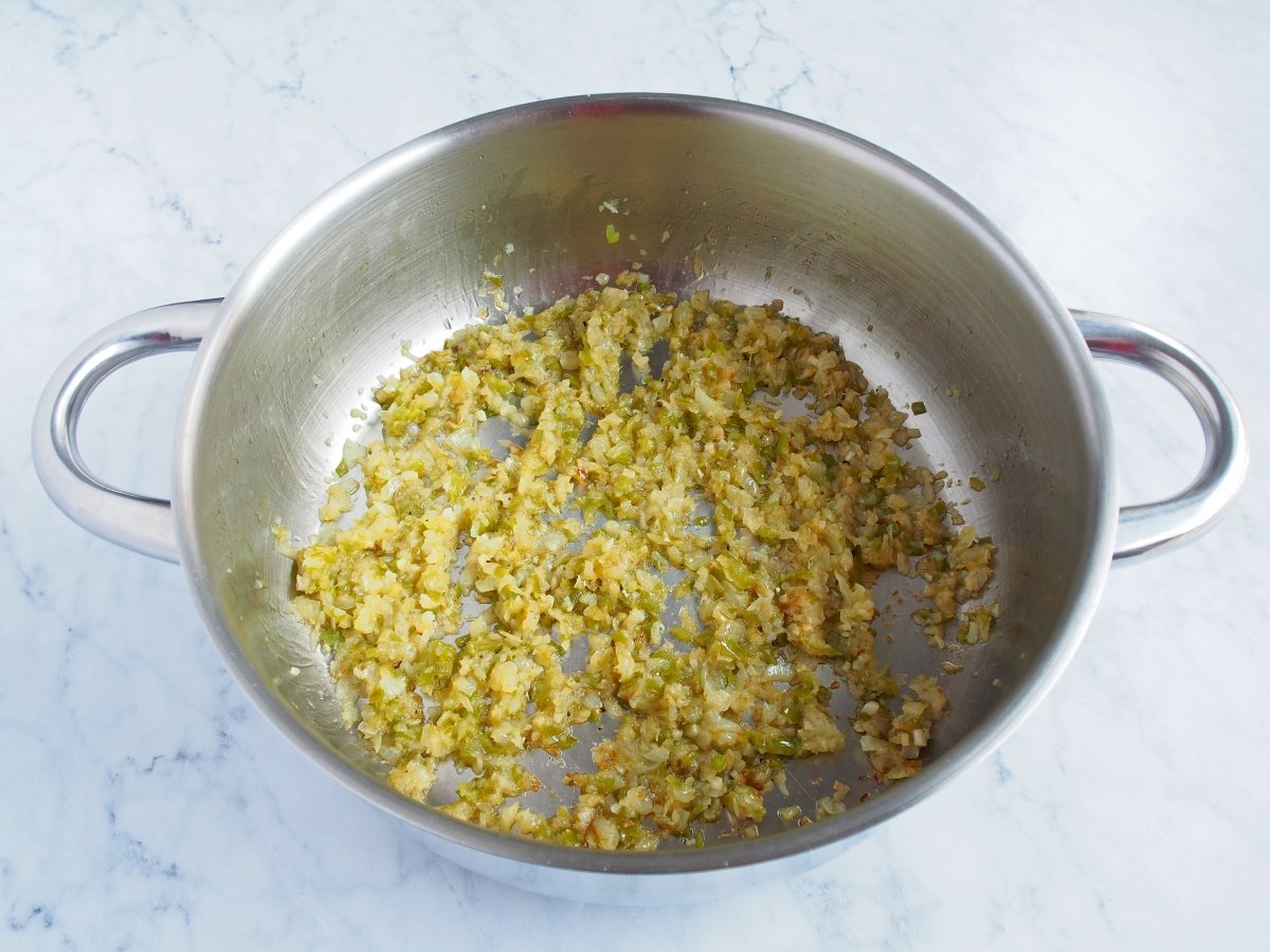 En una cazuela a fuego medio con aceite de oliva cocinamos el ajo, la cebolla y el pimiento verde