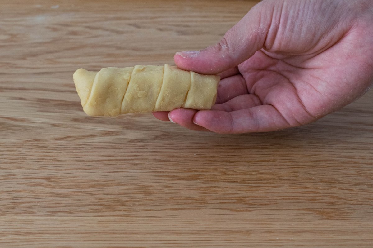 We roll the dough around the cheese strip of the cheese tequeños