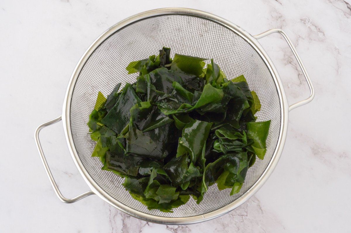 Escurrir el alga para la ensalada wakame