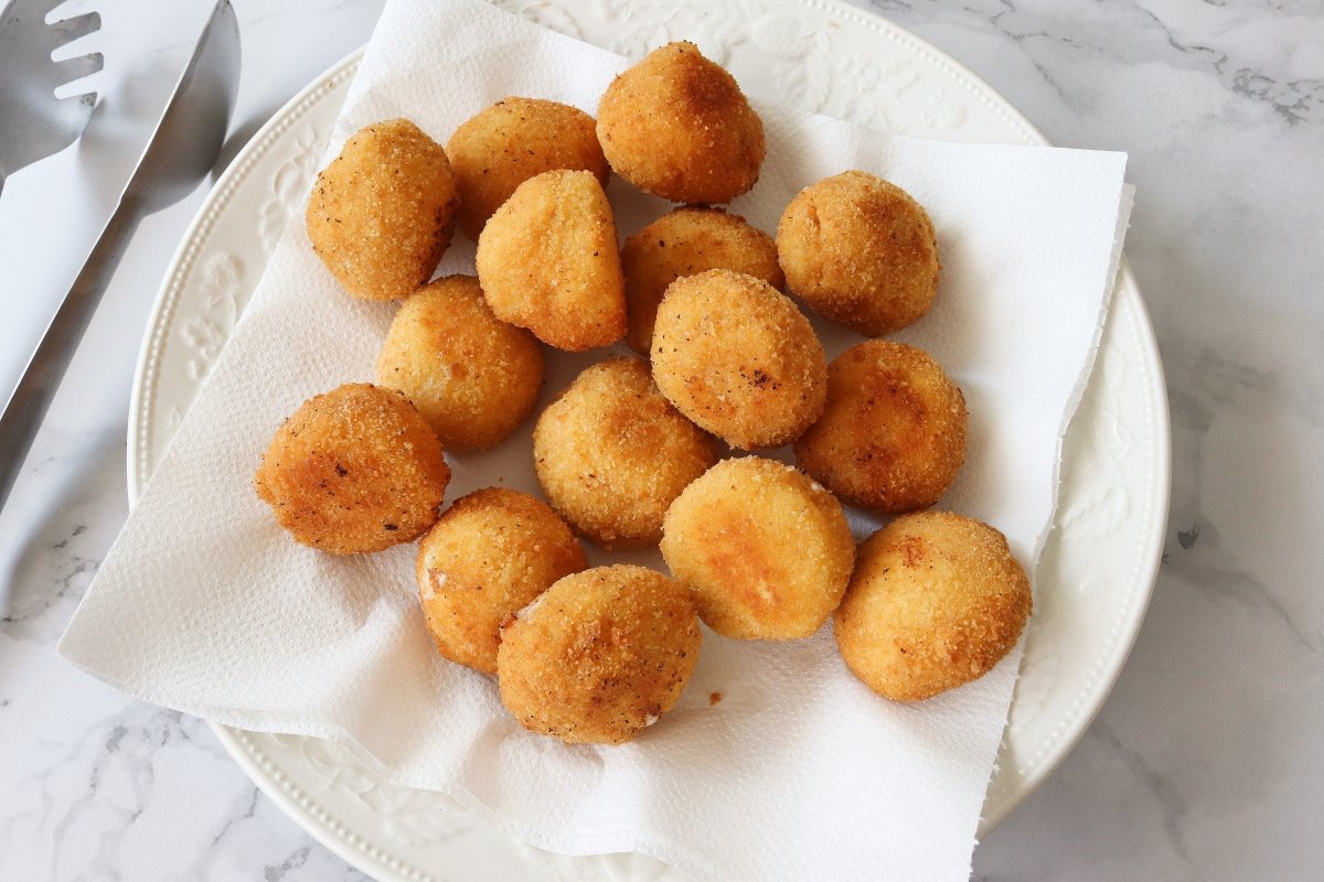 Escurrir el exceso de aceite de la fritura y servir las croquetas de queso
