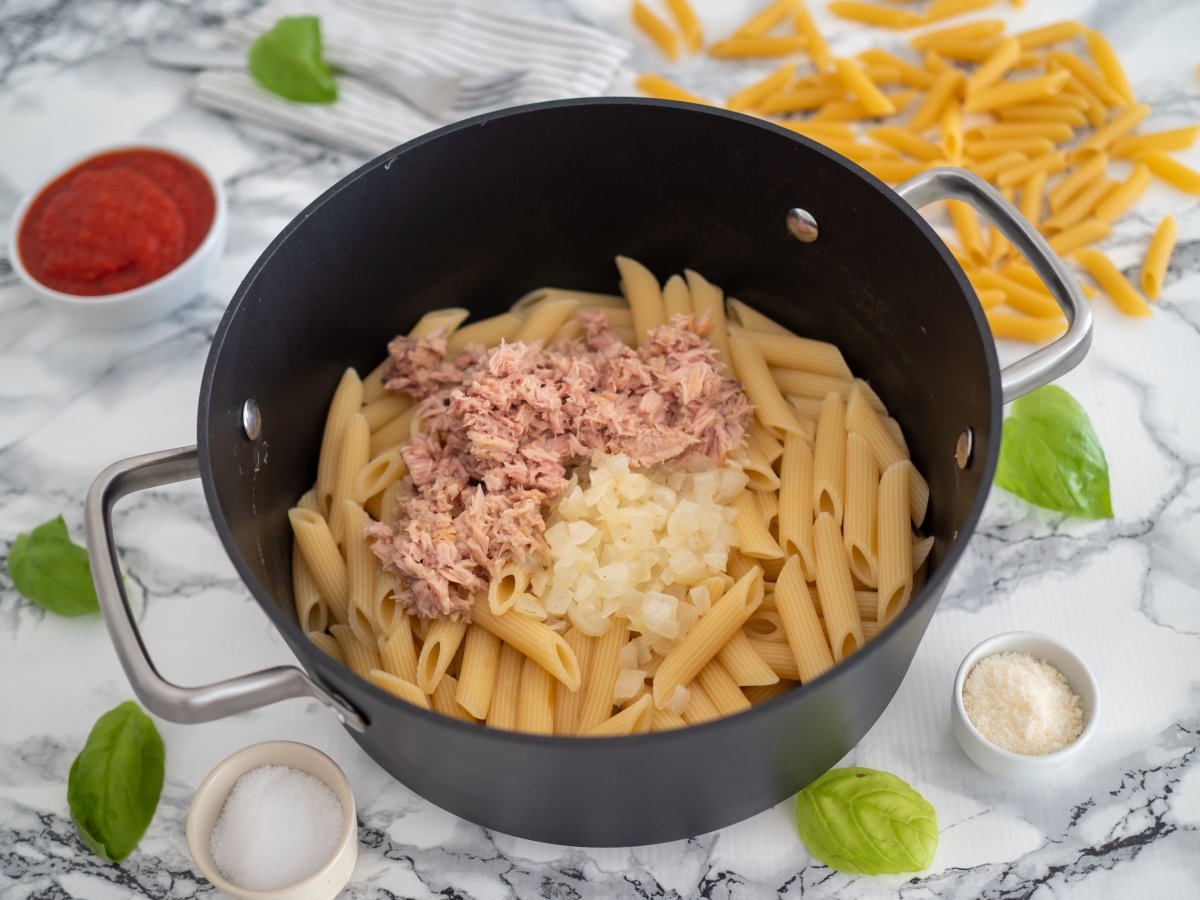 Escurrir los macarrones y añadir la cebolla y el atún en conserva para los macarrones con atún y tom