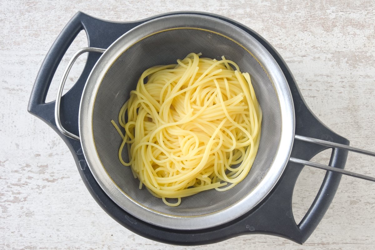 Espaguetis cocidos escurriendo sobre un colador