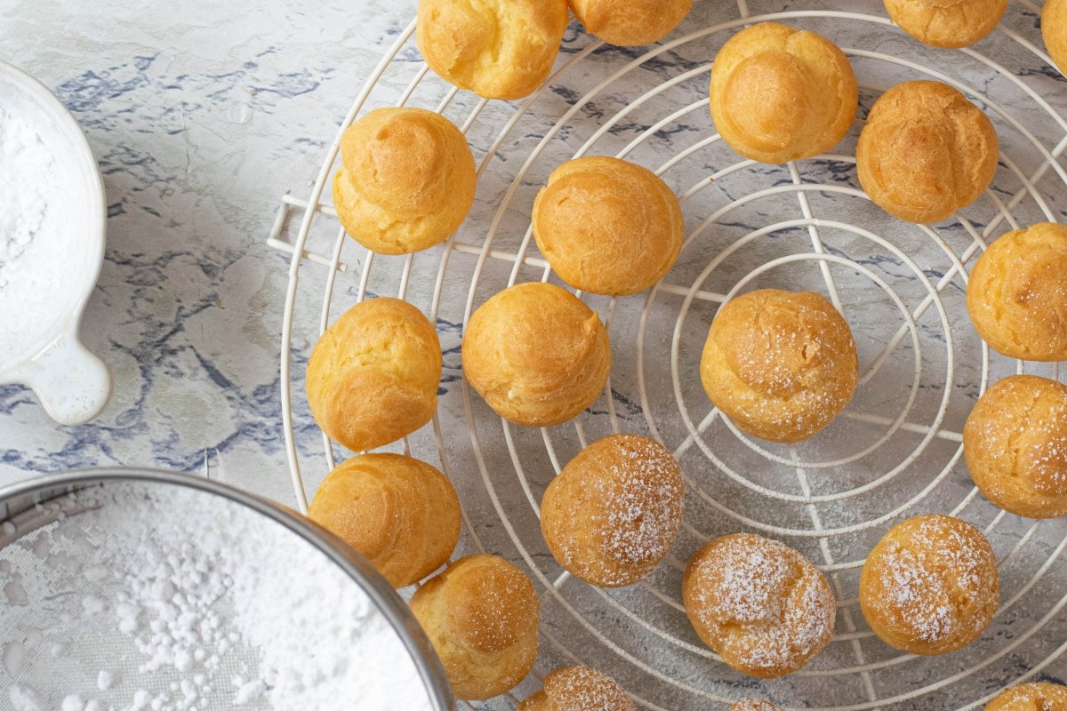 Sprinkle the cream profiteroles with icing sugar.