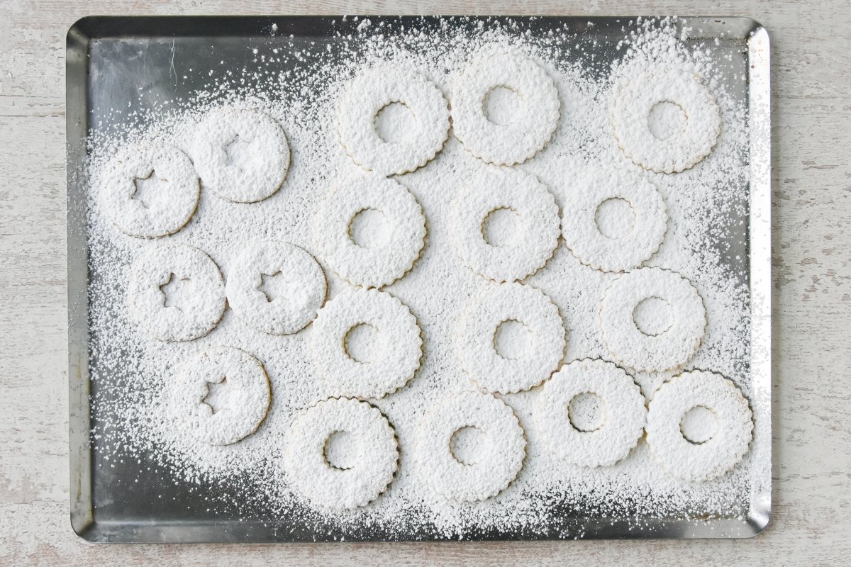 Espolvoreamos las galletas con agujero con azúcar glas