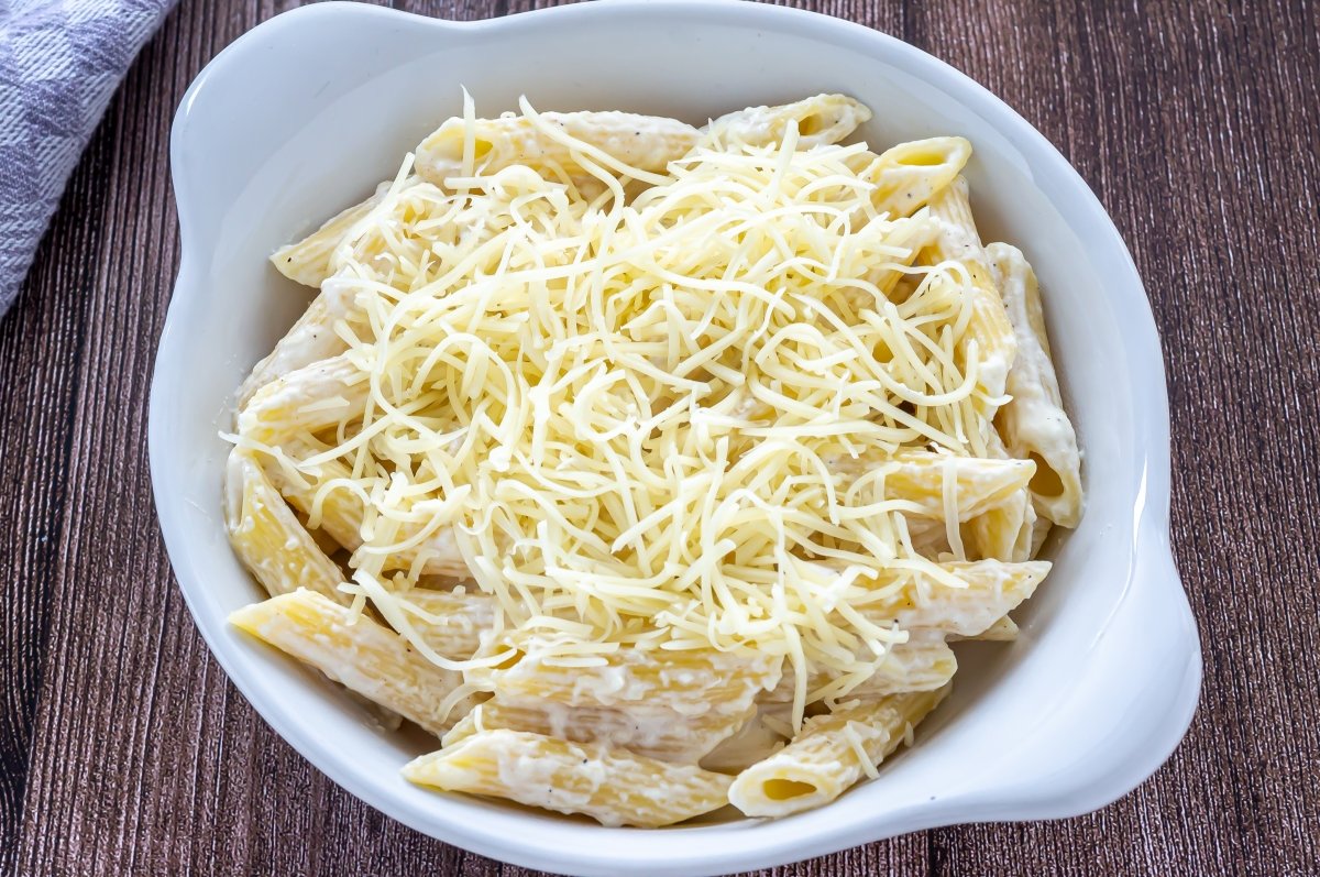 Espolvorear el queso para gratinar los macarrones