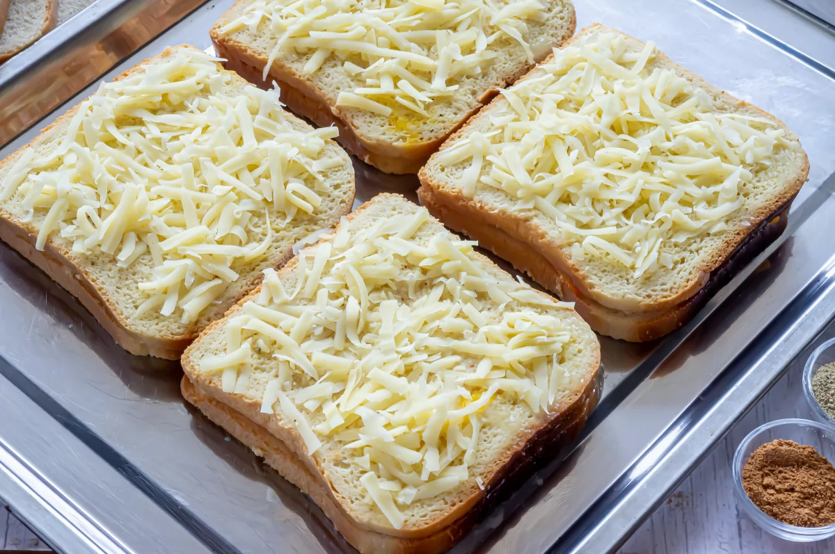 Sándwich de queso al horno 5 Espolvorear los sándwiches de queso con queso rallado *