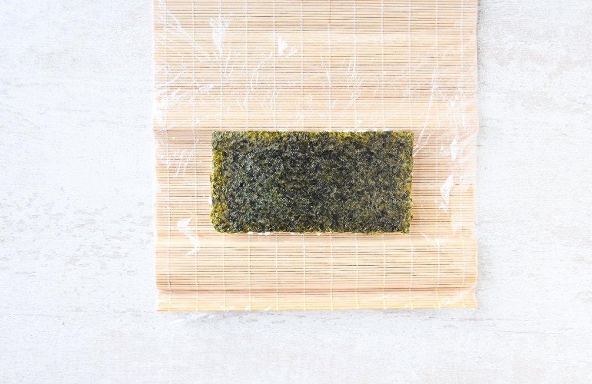 Esterilla para sushi con el arroz cubierto con alga nori