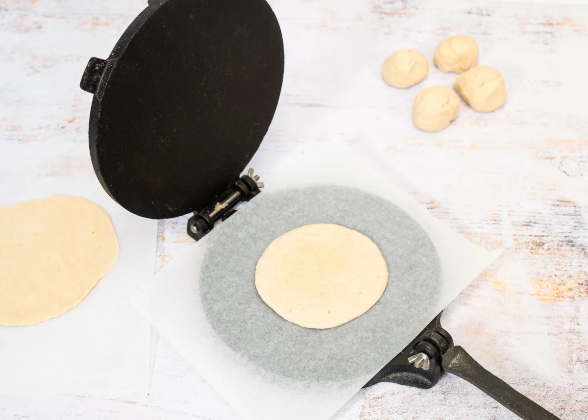 Estirando la masa de las tortillas de trigo con prensa