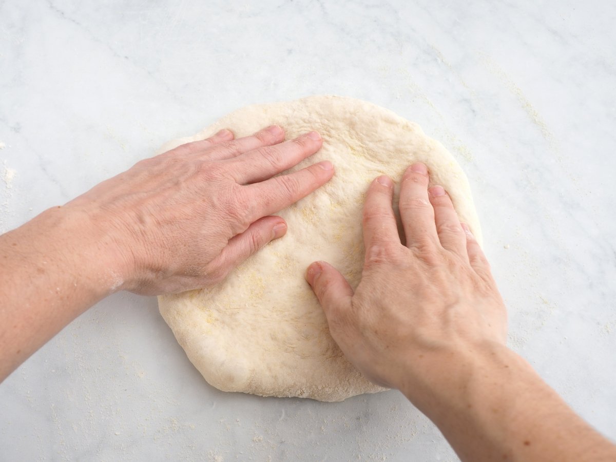 Estirar la masa de la pizza para la pizza primavera