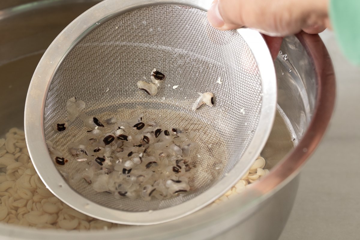 Estrujamos las alubias y retiramos las pieles que flotan