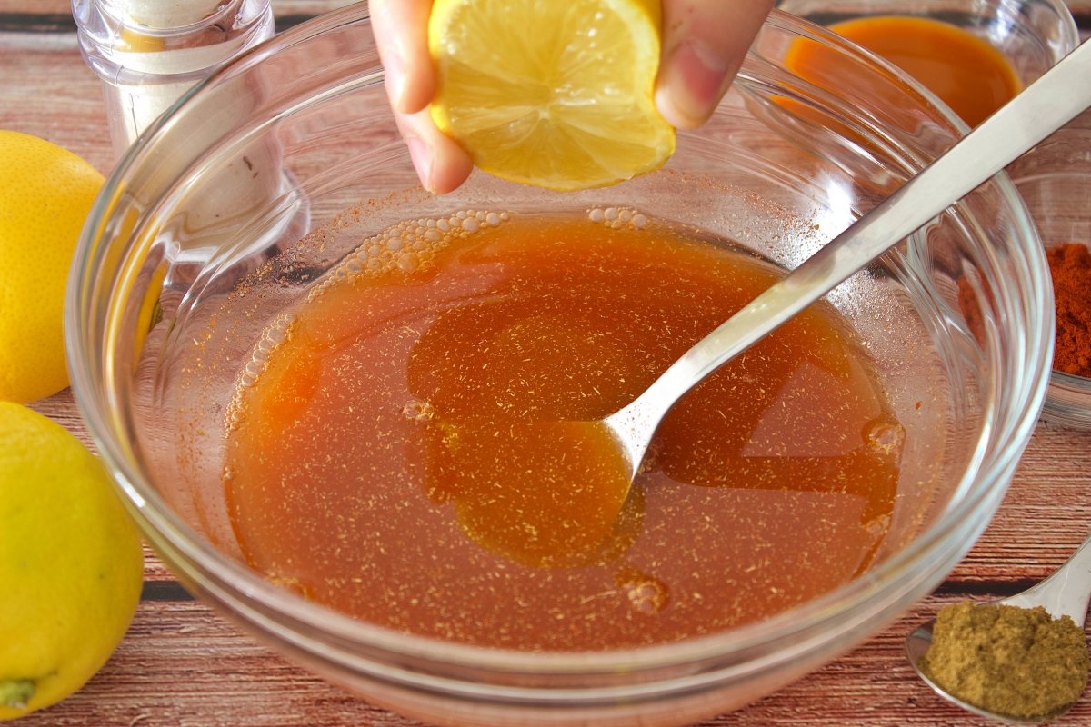Exprimiendo un limón en el bol de la salsa espinaler