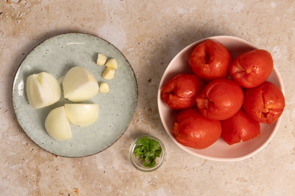 Exprimir los tomates, Trocear la cebolla, los dientes de ajo y la albahaca