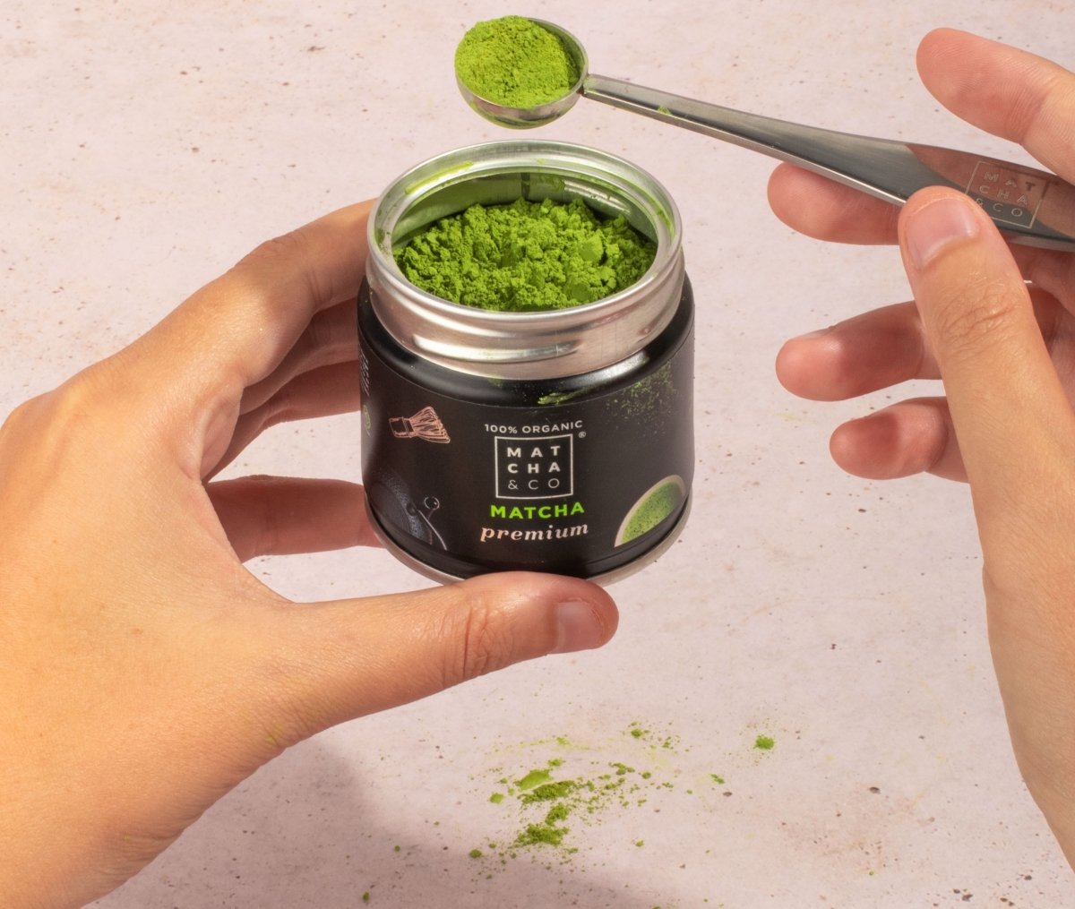 Extrayendo té matcha de su envase de Matcha & CO con una cuchara medidora de té