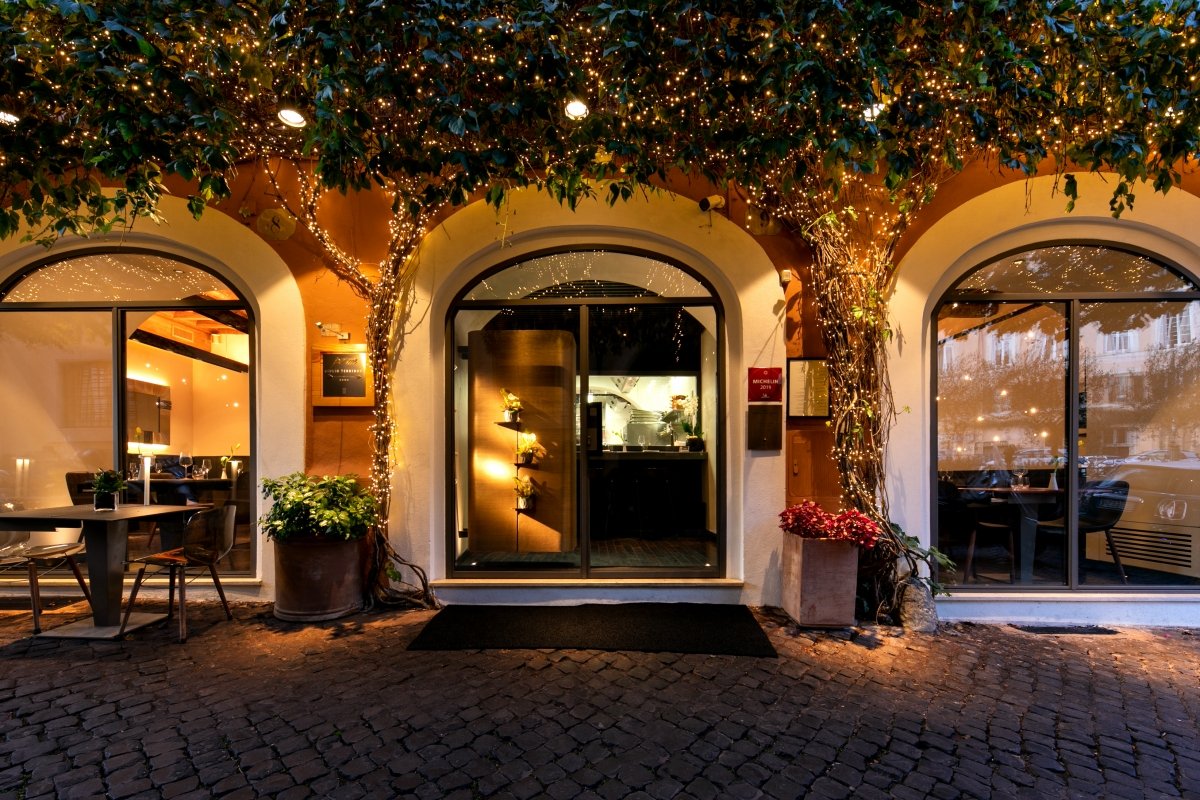 Fachada iluminada del restaurante romano Per Me de Giulio Terrinoni