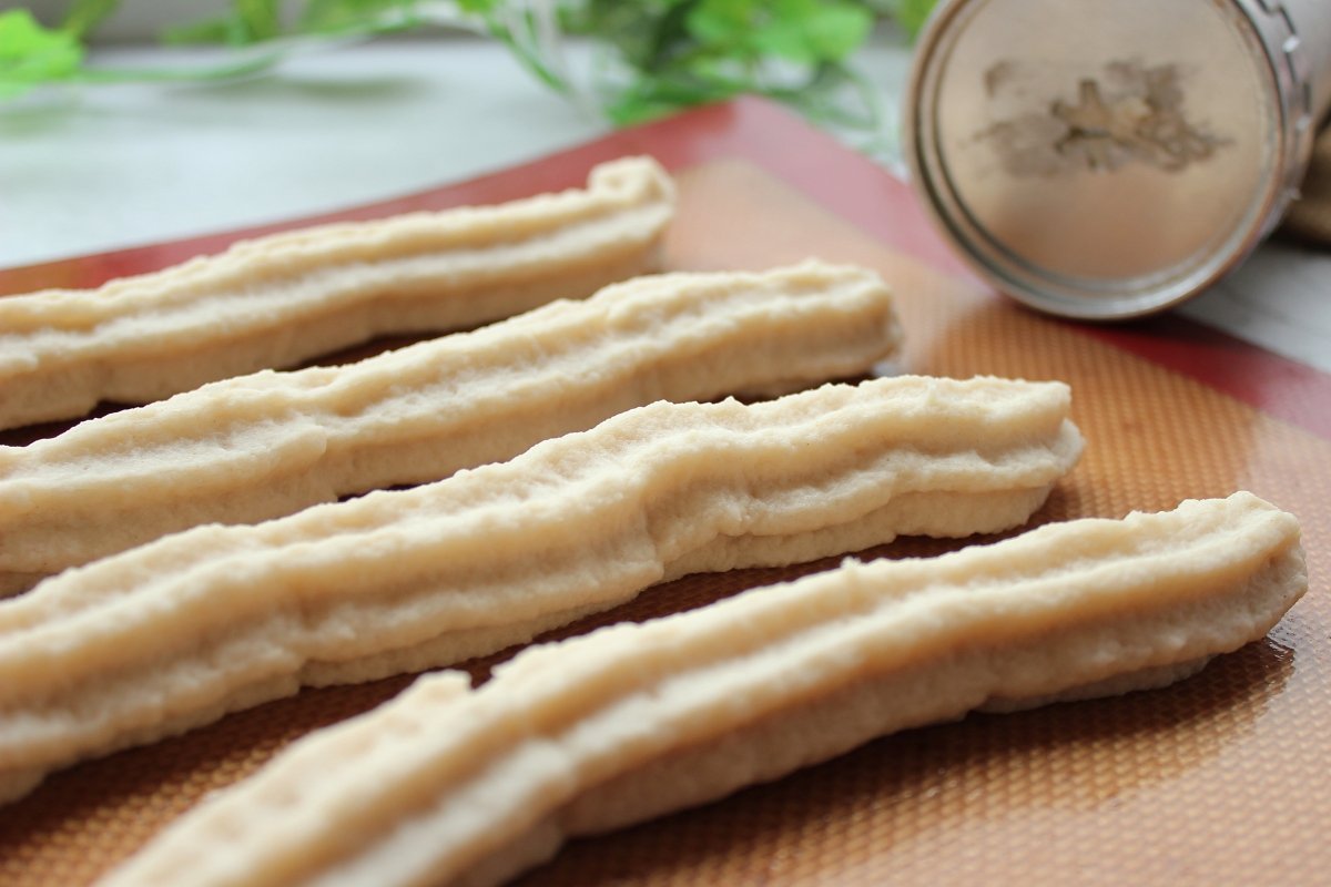 Formar los churros con la churrera