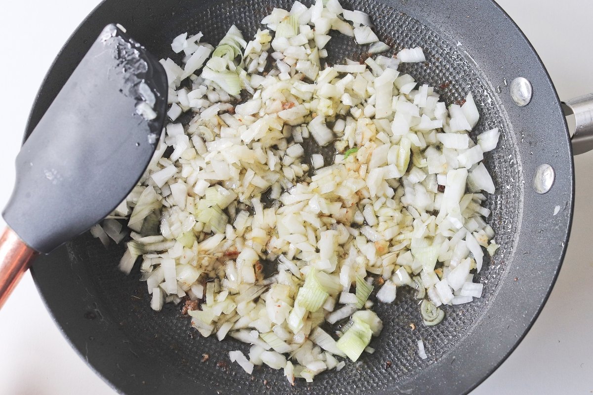 Freír la cebolla y el ajo para las albóndigas de carne en salsa verde