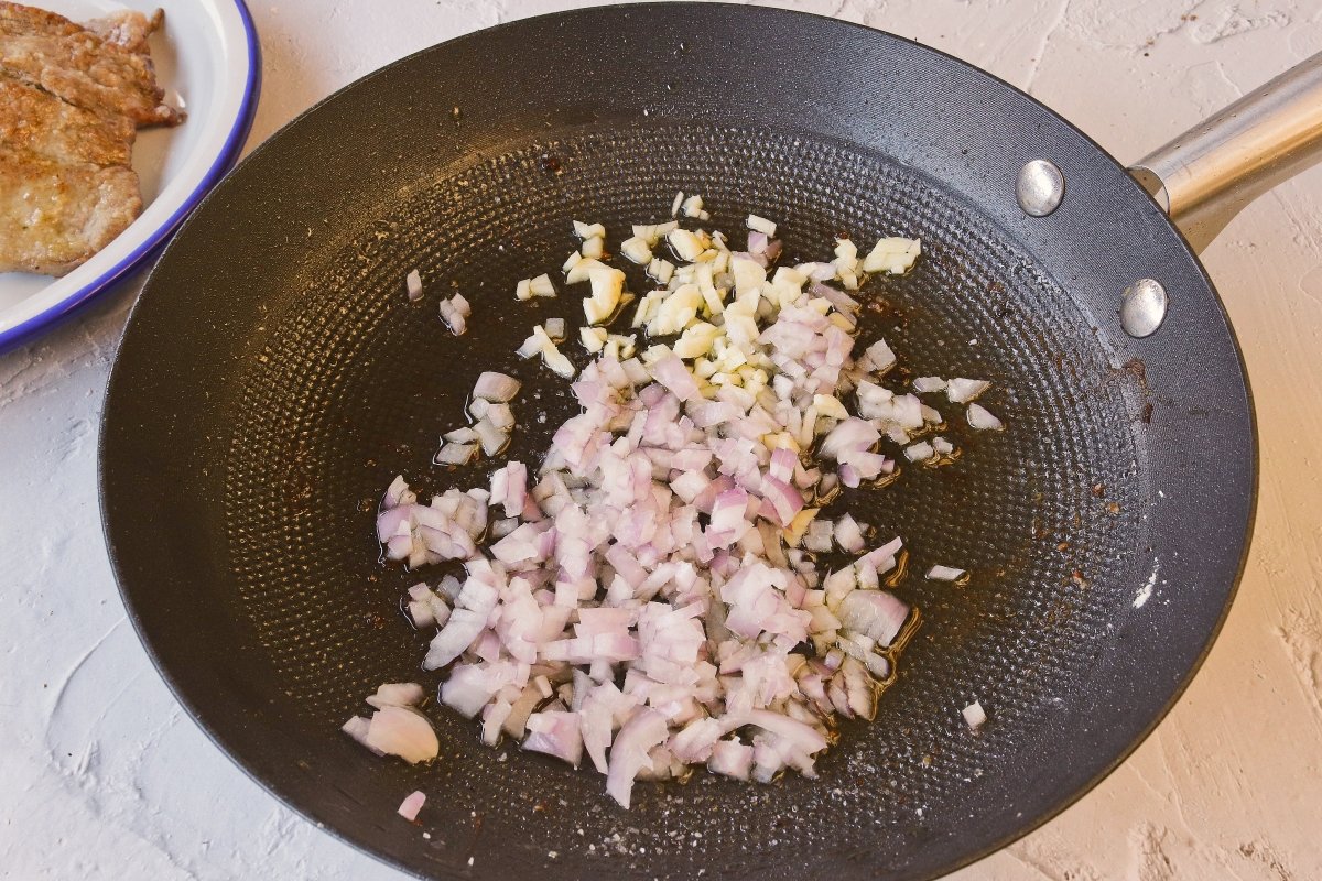 Freír cebolla y ajo para la salsa de los escalopines de ternera