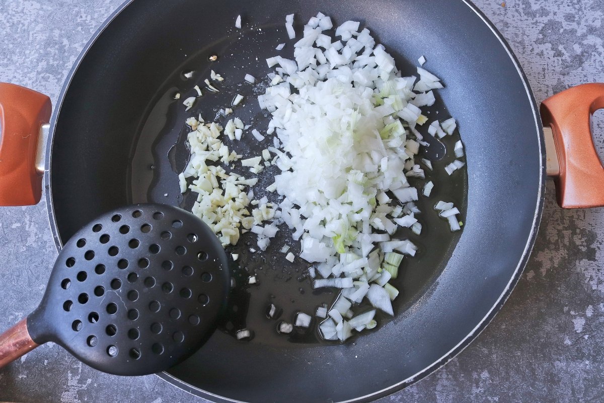 Freír cebolla y ajos para el curry de garbanzos