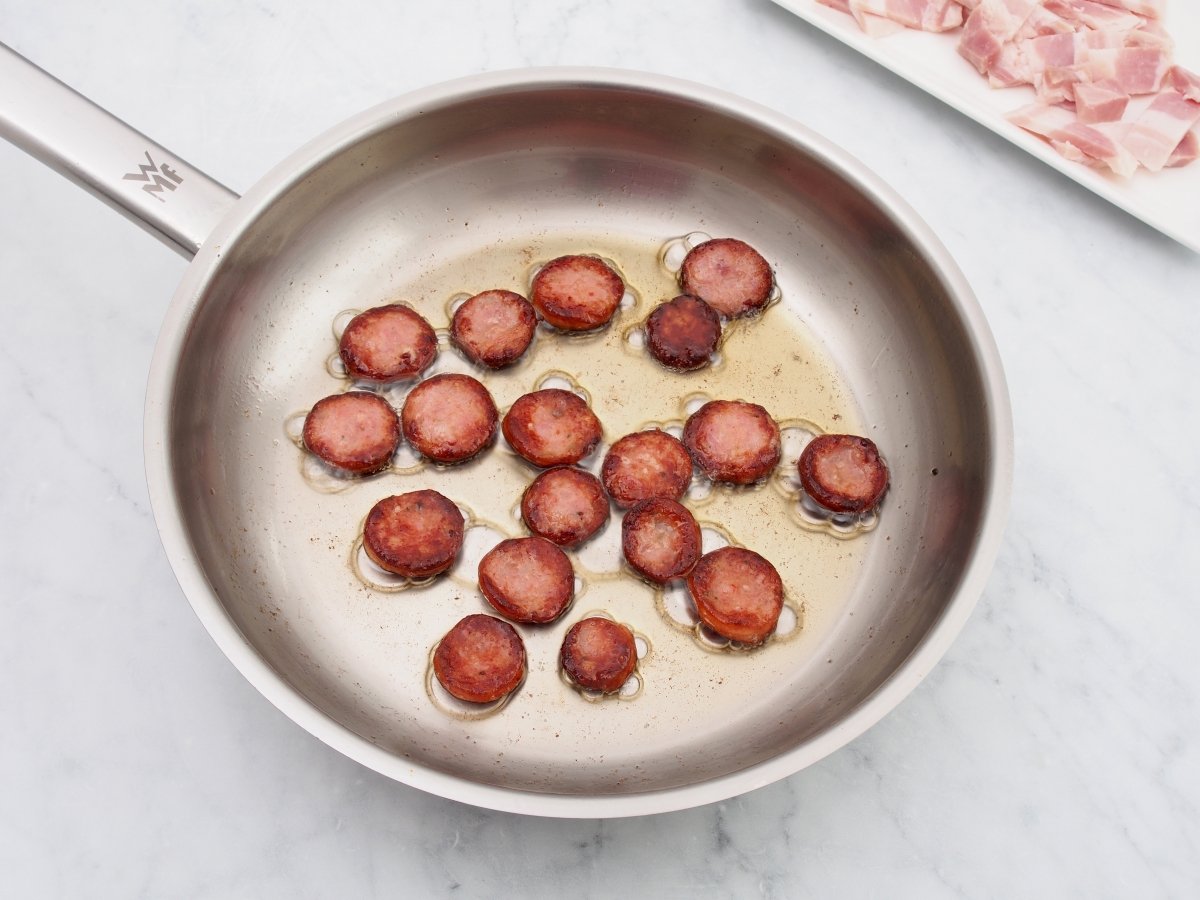 Freír el chorizo para el arroz paisa