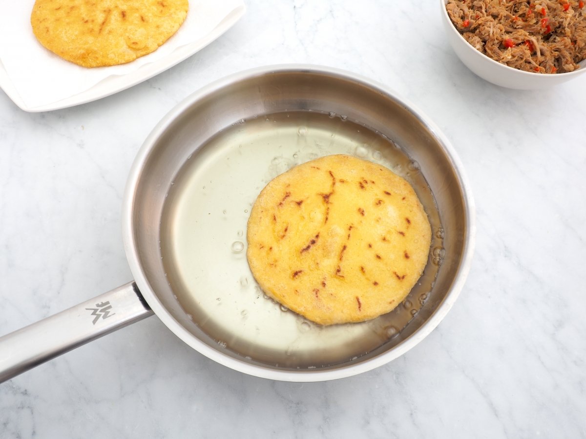 Freír las arepas para las arepas cabimeras