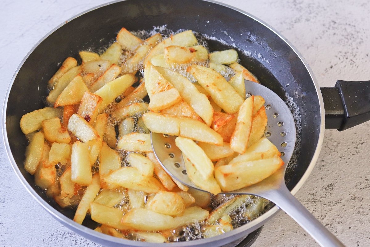 Freír las patatas para el prego no prato