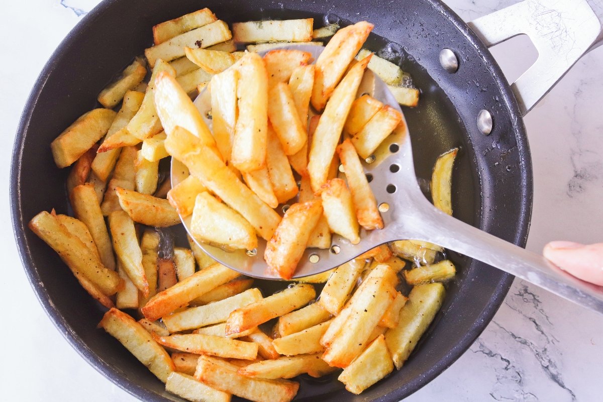 Freír las patatas para la yaroa dominicana