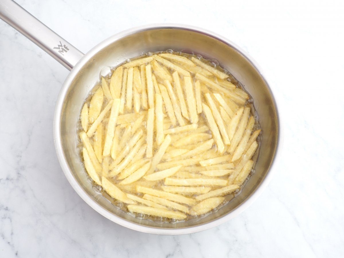 Freír las patatas para los moules frites
