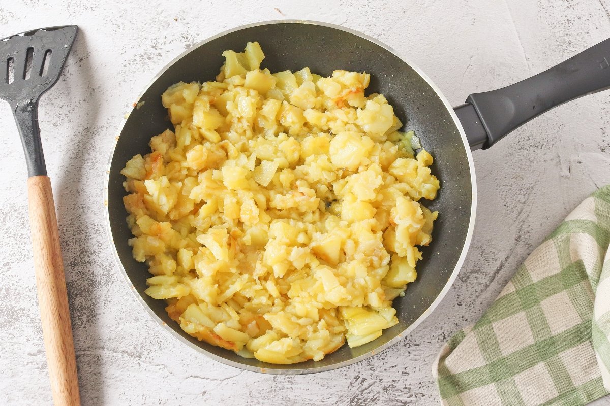 Freír las patatas y la cebolla para la tortilla rellena de jamón y queso