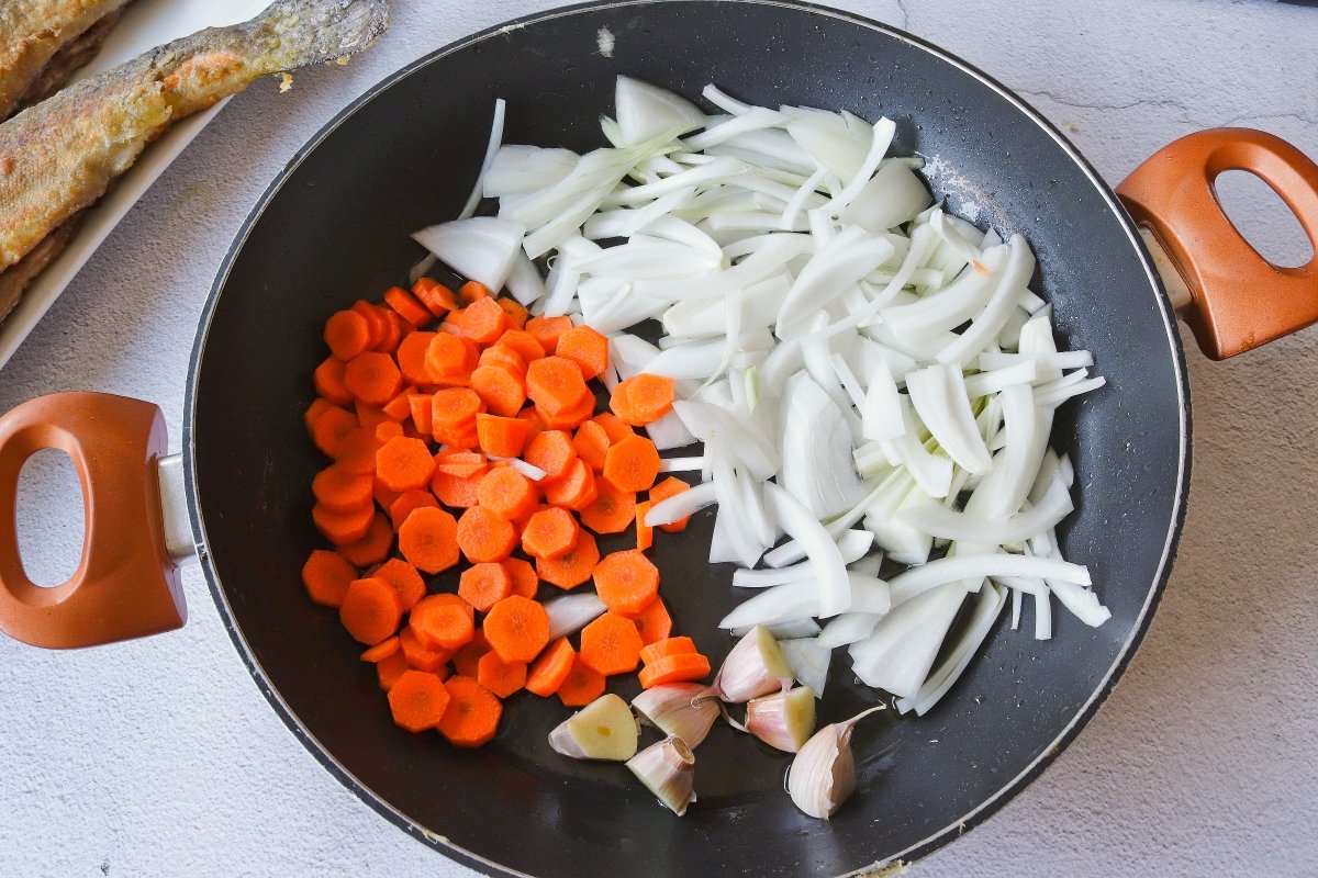 Freír las verduras para hacer las truchas en escabeche