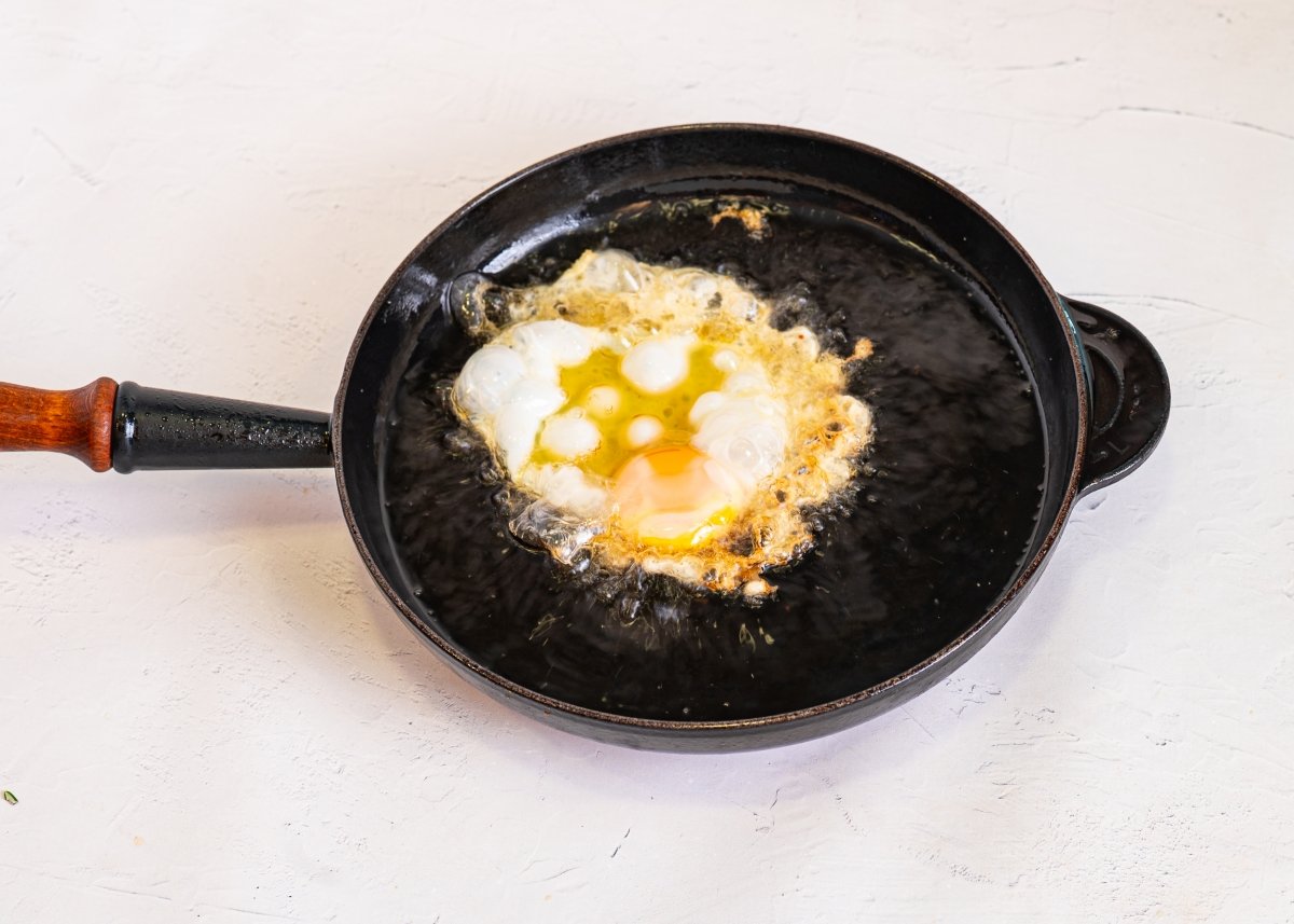 Friendo huevos para hacer plato de los montes