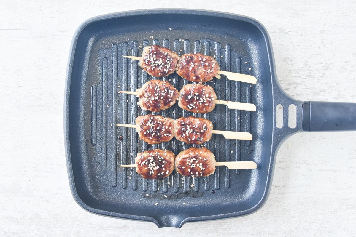 Glaseamos las tsukune y espolvoreamos con sésamo