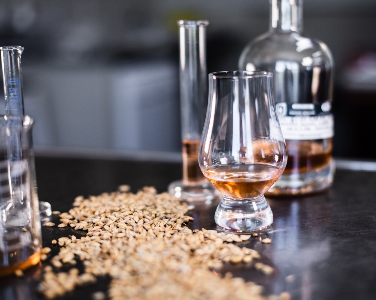 Granos de cereales y vasos de cristal con whisky