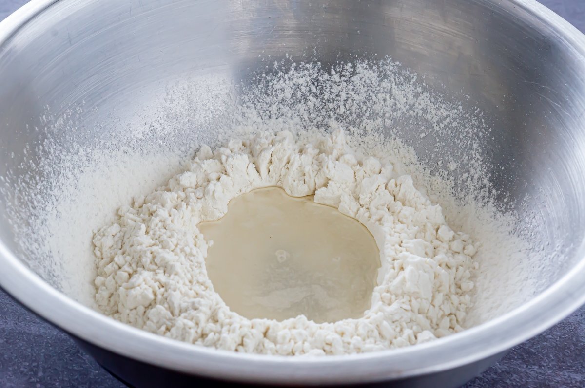 Hacer un agujero en la harina y llenar con agua