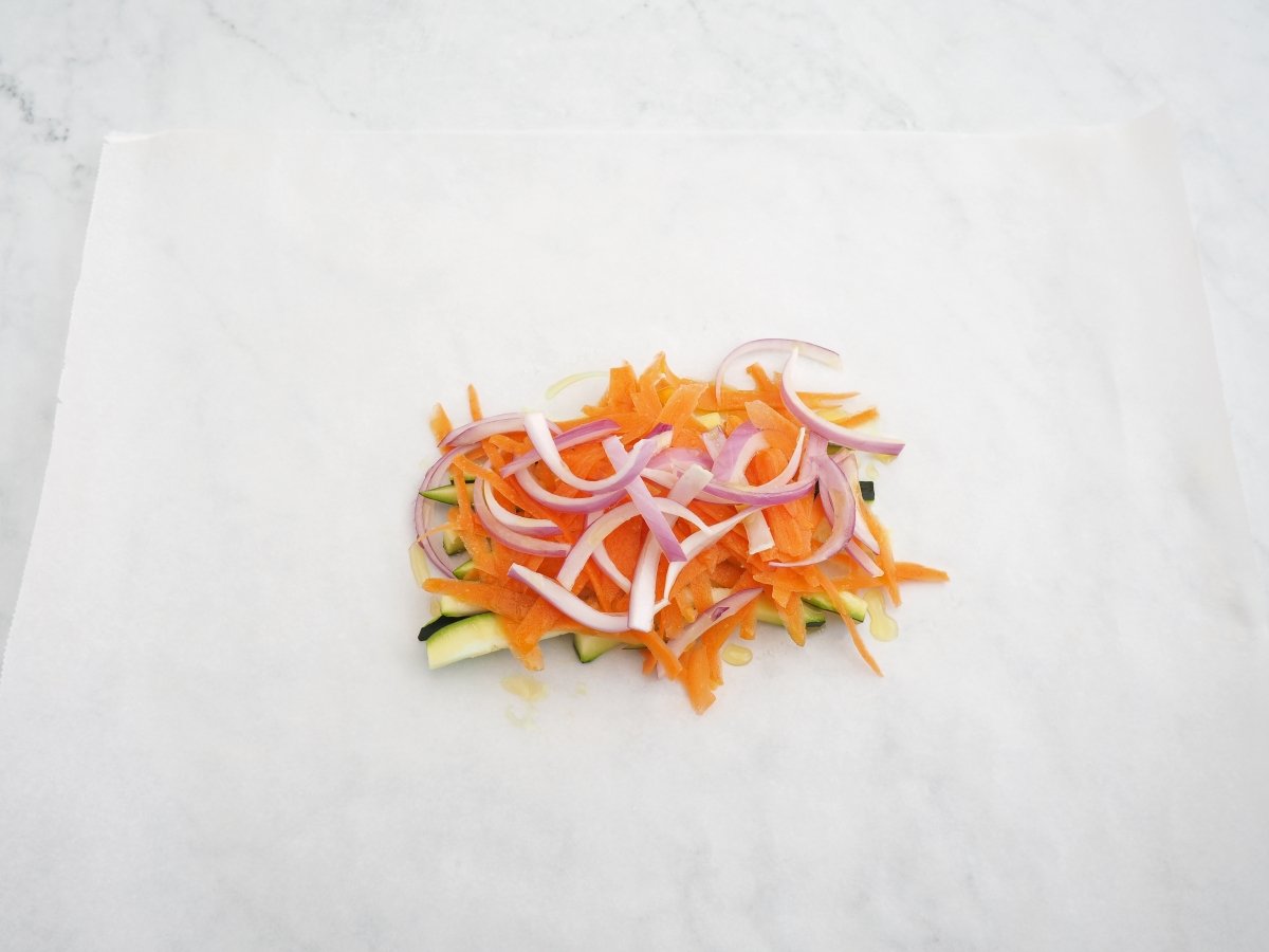 Hacer una cama con las verduras sobre el papel vegetal