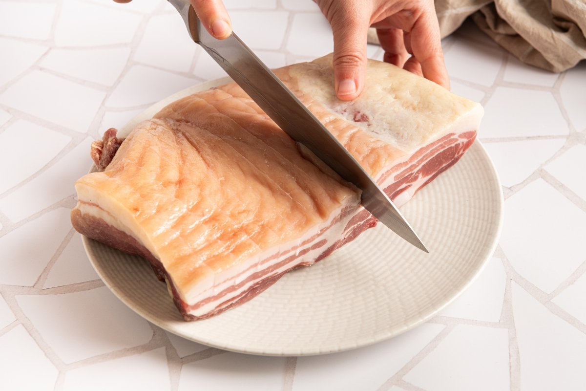 Haciendo cortes en la piel para hacer panceta al horno