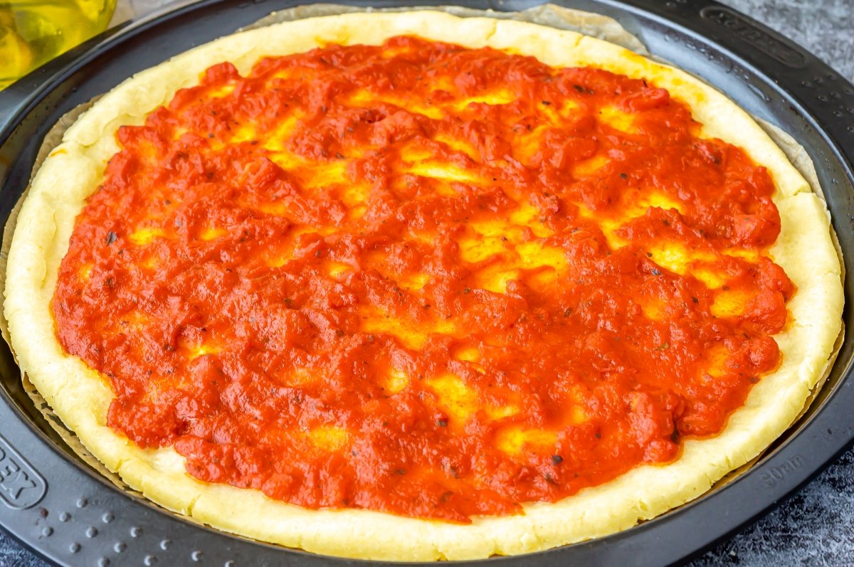 Hornear la masa de pizza sin gluten con la salsa de tomate