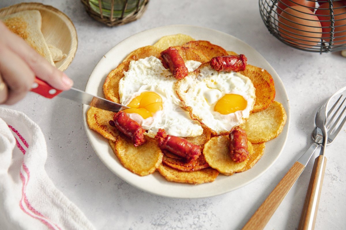 Huevos rotos con chistorra servidos