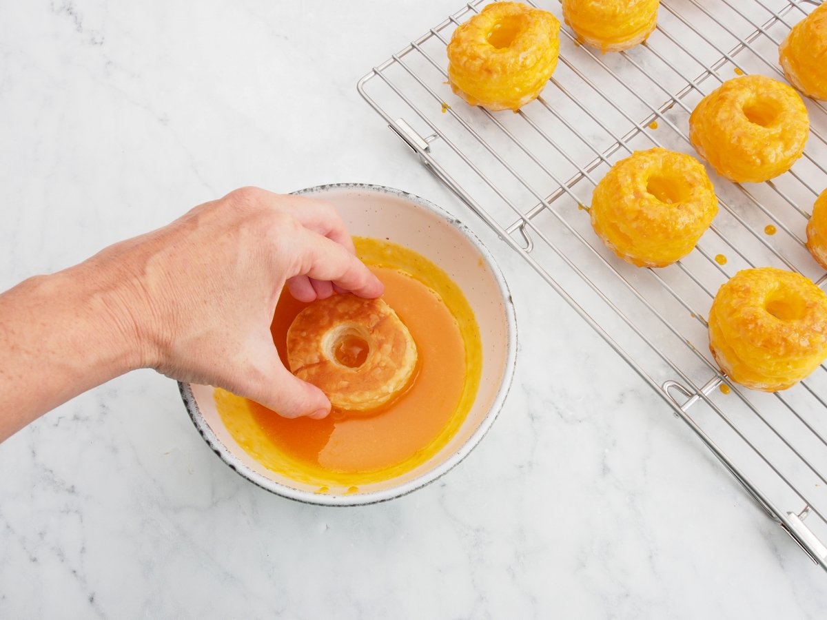 Impregnar las rosquillas en la crema de yema para las rosquillas de Alcalá