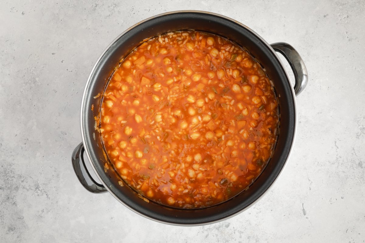 Incorporando arroz a los garbanzos con arroz