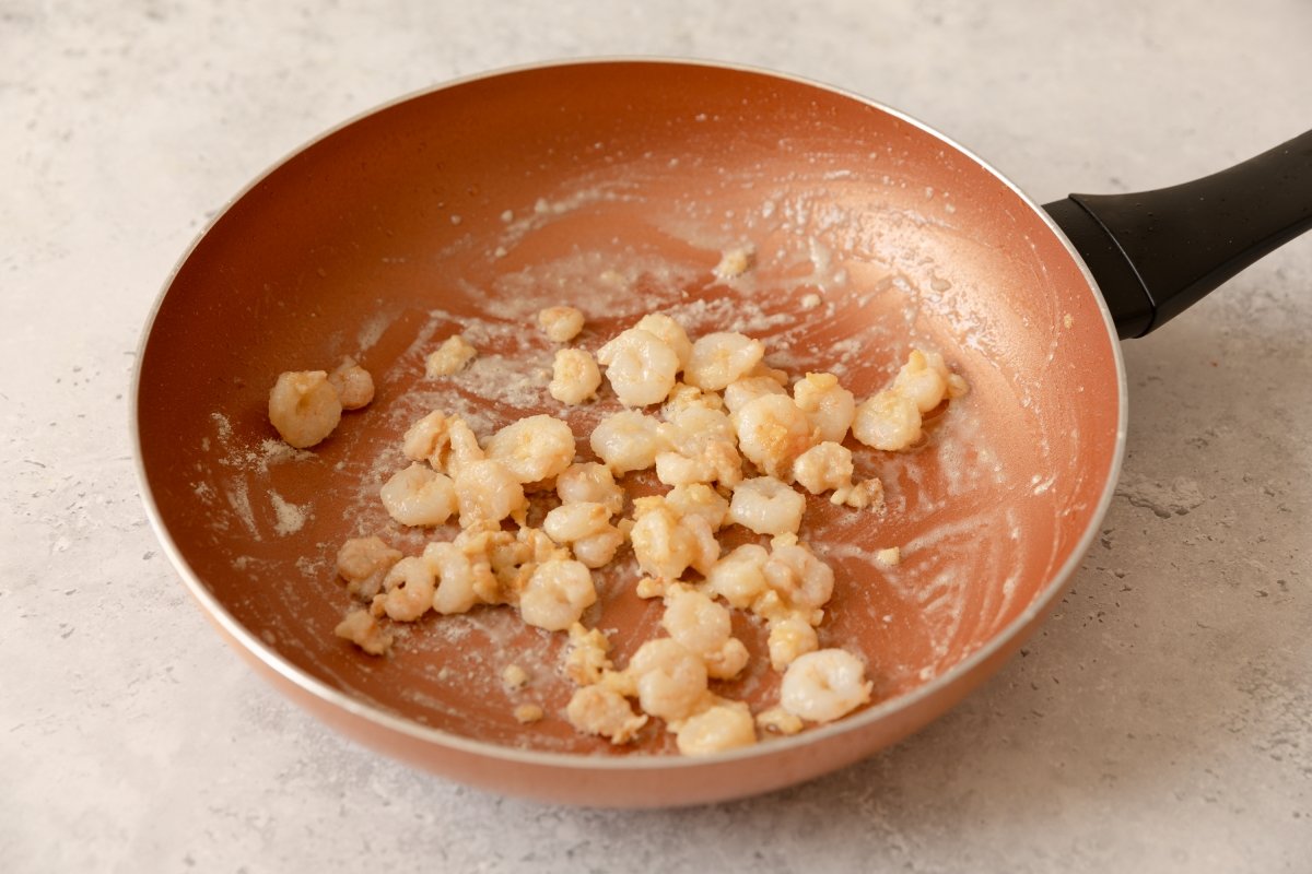 Incorporando gambas a la merluza en salsa