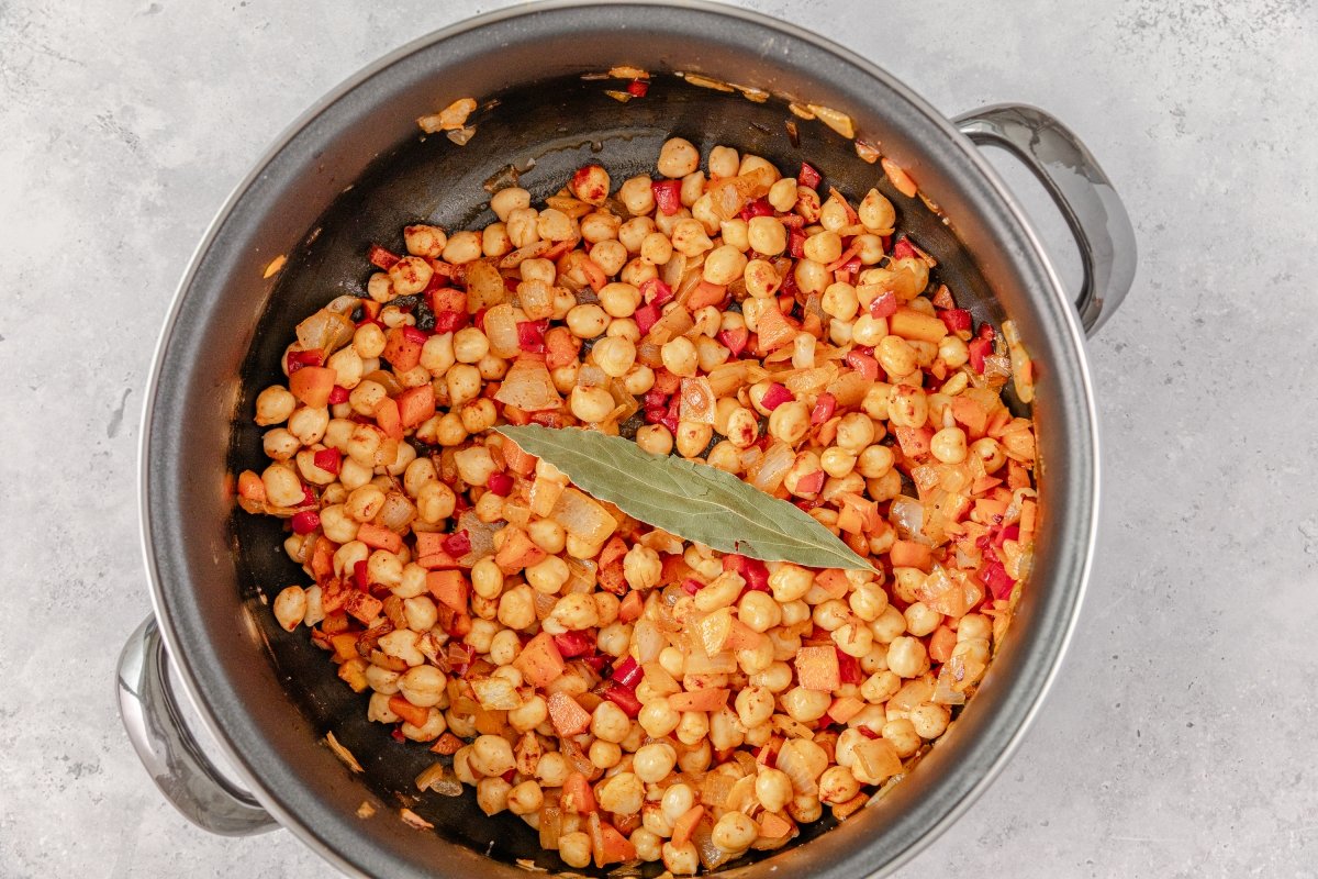 Incorporando garbanzos all potaje de garbanzos con verduras