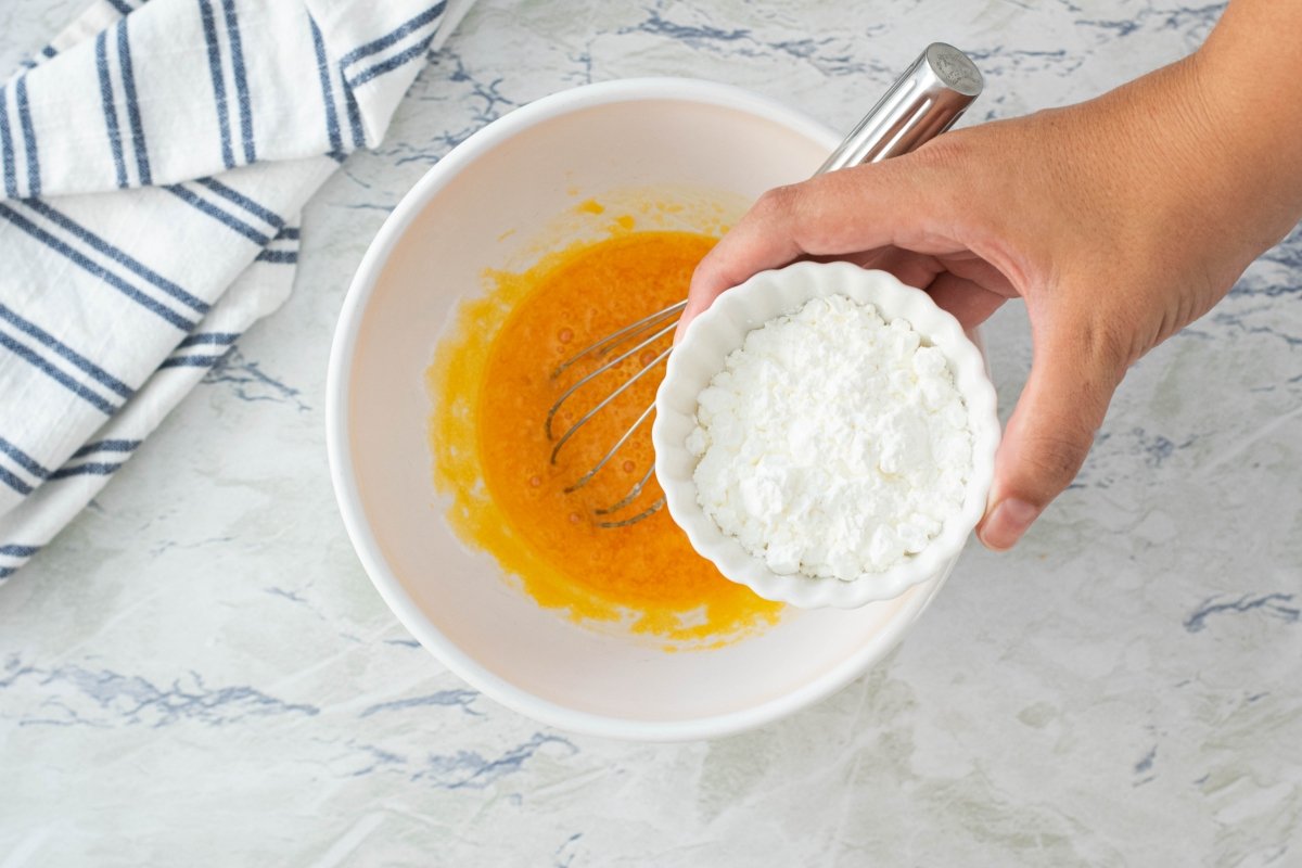 Incorporar a la mezcla de azúcar y yemas la maicena diluida para hacer la crema pastelera