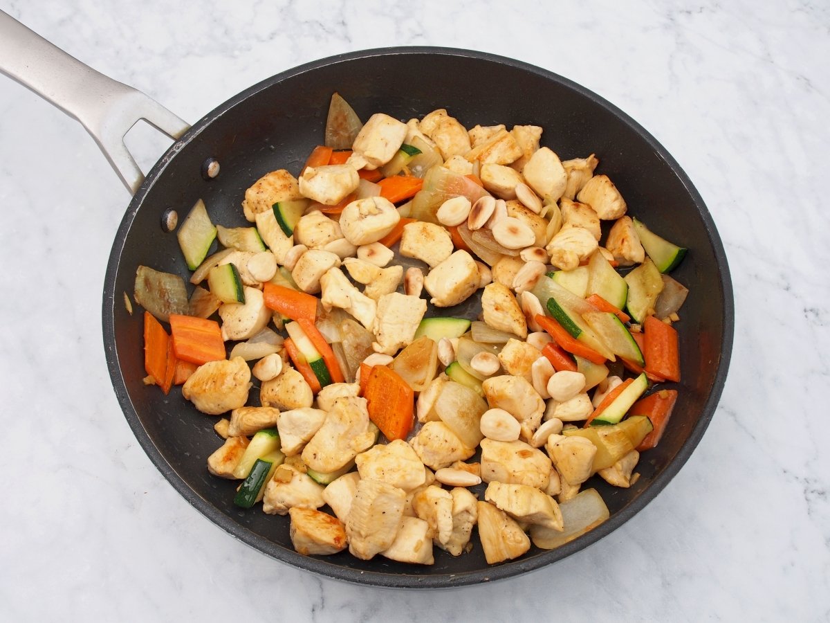 Incorporar a la sartén las almendras y las verduras para el pollo con almendras al estilo chino