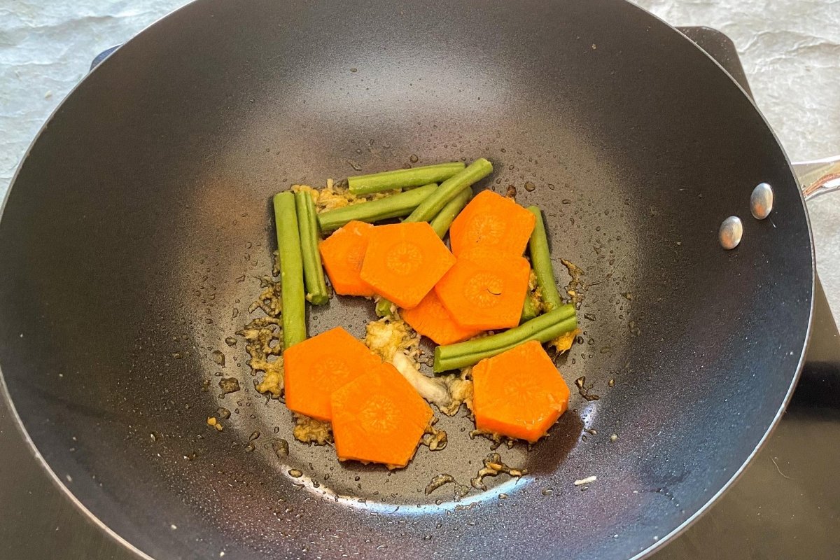 Incorporar al wok la zanahoria y las judías verdes