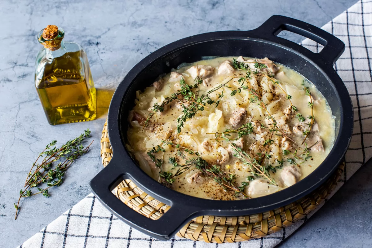 Incorporar caldo y hierbas para hacer el cerdo guisado con cebolla *