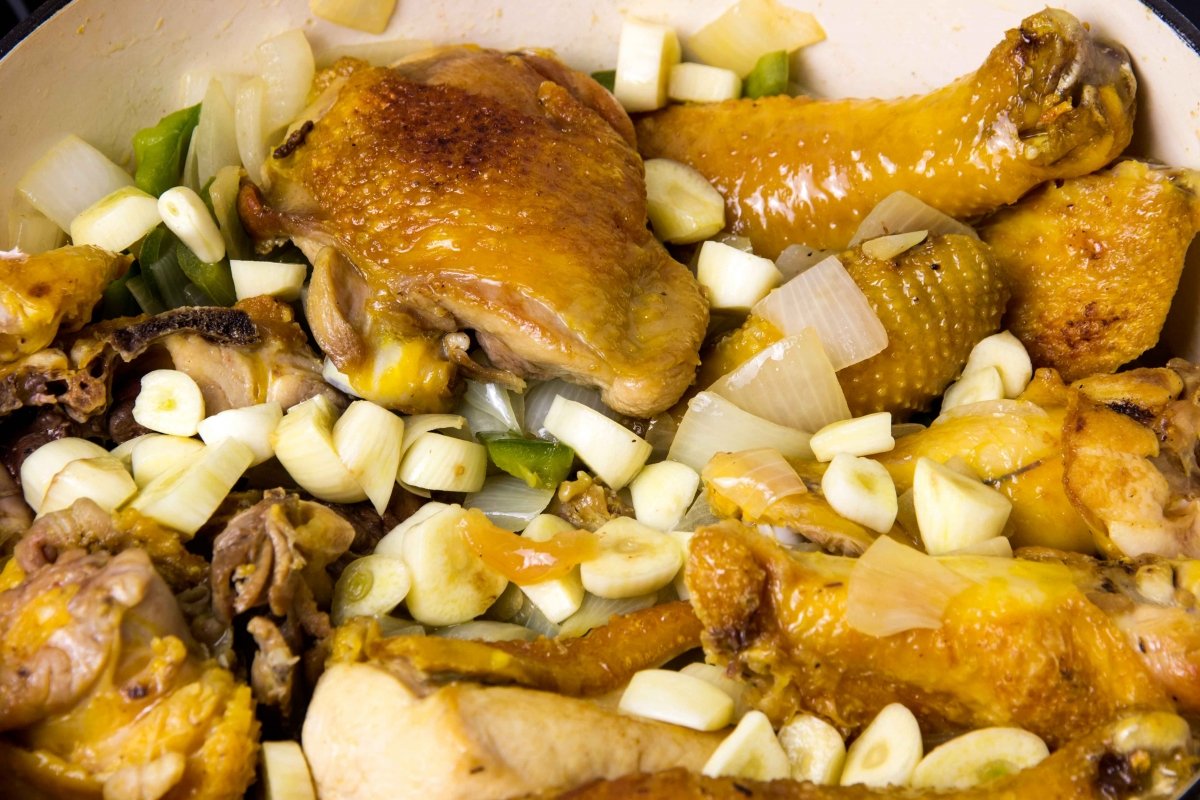 Incorporar el pollo, pimiento verde, ajos y organos a la cazuela del pitu caleya