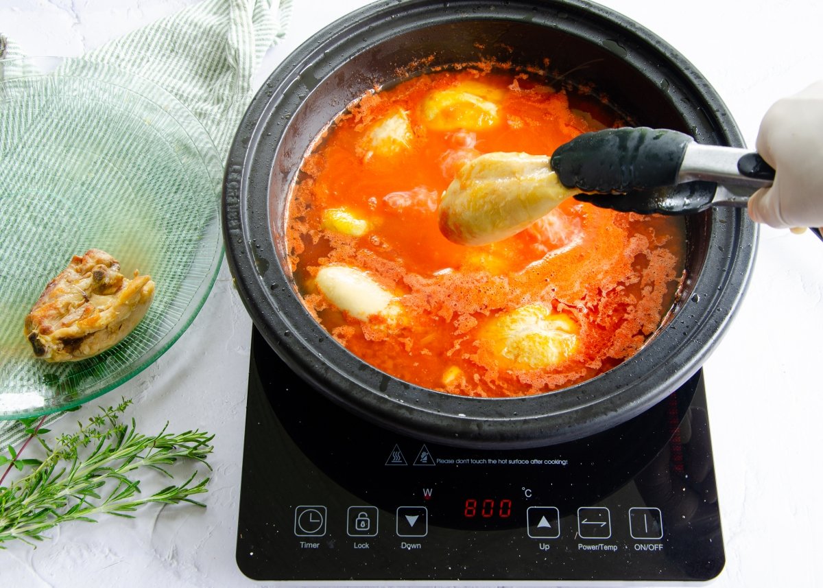 Incorporar el tomate triturado a la olla con el pollo